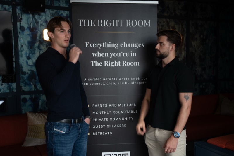 Two members talking beside The Right Room banner