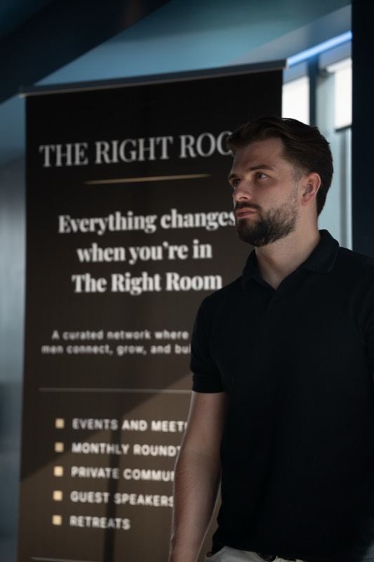 Derek beside The Right Room banner